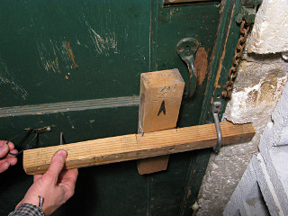 Compression bar to close basement door