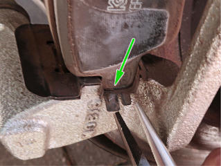 The annoying tab retaining the brake pad ears