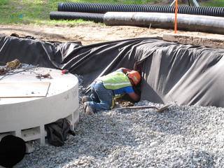 Hand digging around catch-basin outlet